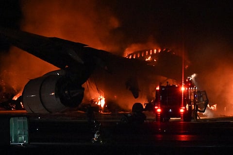 A Japan Airlines plane was in flames on the runway of Tokyo's Haneda Airport on 2 January after apparently colliding with a coast guard aircraft, television reports said. (Photo by Richard A. BROOKS / AFP)