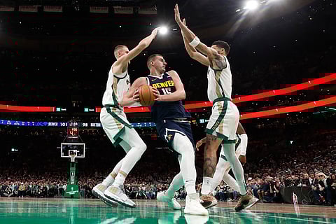 Denver’s Nikola Jokic gets double-teamed by the Boston duo of Kristaps Porzingis and Jayson Tatum but the Nuggets still edge the Celtics, 102-100, in their NBA regular season game. | WINSLOW TOWNSON/AGENCE FRANCE-PRESSE