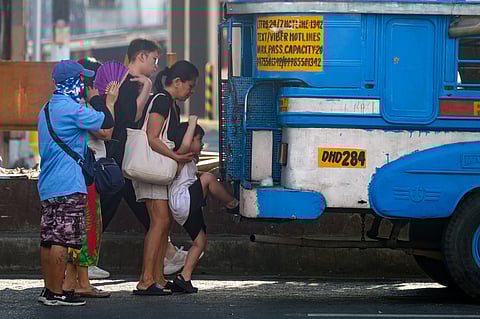 A woman helps a child ride the Public Utility Jeepney  in Makati on Friday, 5 January 2023. The Land Transportation Franchising Regulatory Board guidelines extended the grace period for unconsolidated PUJs to ply their routes from December 31, 2023 to January 31, 2024. | Photo by King Rodriguez. 