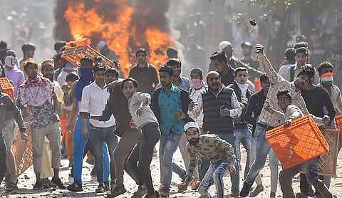File photo: A crowd gathers amid flames and smoke during the 2020 northeast Delhi riots.