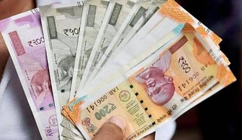 Representational image: A hand holding a stack of Indian rupee banknotes.