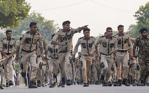 Security personnel run towards demonstrators to disperse them during a CJP protest at Connaught Place in New Delhi, Saturday, October 10. (PTI Photo)