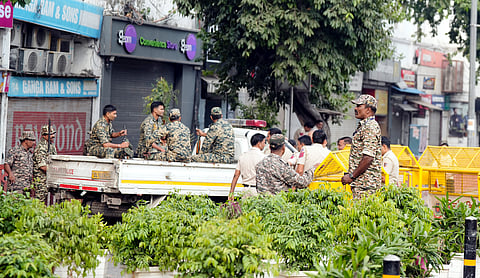 Security personnel stand guard and place barricades along the Outer Circle of Connaught Place. PTI image.