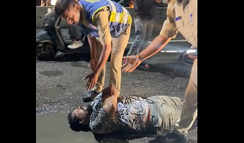 A man lies on a Hyderabad road in protest against potholes. Photo: X