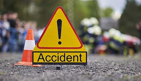Representational image: An accident warning sign and traffic cone on a road.