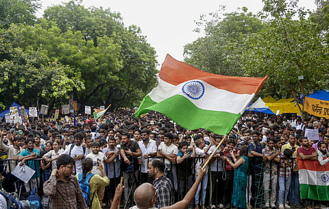 File photo: Protesters, many holding placards and Indian national flags, gather behind metal barricades during a demonstration against the examination system, RANCHI. (PTI Photo)