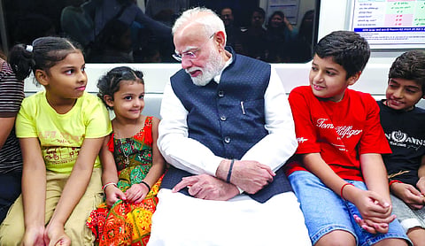 Prime Minister Narendra Modi interacts with children as he travels by Delhi Metro en route to Shri Ram College of Commerce (SRCC) for its centenary celebrations in New Delhi	PTI
