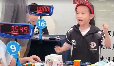 File photo: Lian Yunzhi solving a Rubik’s Cube. (China News Service/Reuters)