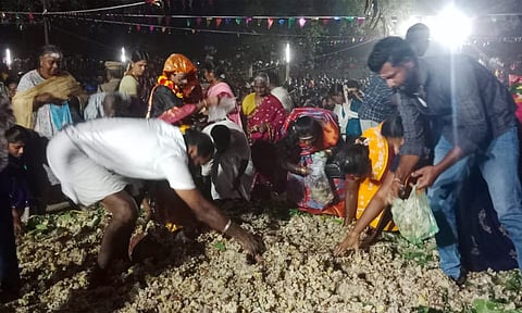 மயான கொள்ளை விழாவில் பக்தர்கள் தானியங்கள் மற்றும் கிழங்கு வகைகளை அள்ளிச் செல்லும் காட்சி.