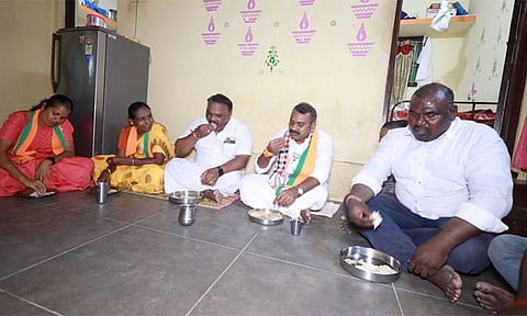 வாக்கு சேகரிப்பின்போது மக்களுடன் அமர்ந்து உணவருந்திய எல்.முருகன்