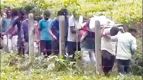 சாலை வசதி இல்லாததால் தொட்டில் கட்டி நோயாளிகளை 1 கி.மீ. தூரம் சுமந்து செல்லும் மக்கள்
