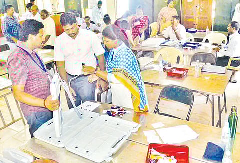 வாக்குப்பதிவு எந்திரங்களில் வேட்பாளர்கள் பெயர், சின்னத்துடன் கூடிய வாக்குச்சீட்டு பொருத்தும் பணி