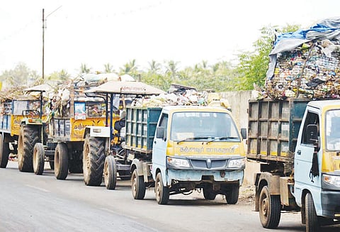 குப்பைகள் கொட்ட இடம் இல்லாததால் சாலையோரம் அணி வகுத்து நின்ற வாகனங்கள்