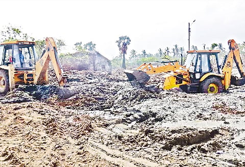 புயலால் பாதிக்கப்பட்ட புஷ்பவனம் பகுதியில் சேற்றை அகற்றி, கடலில் கொட்டும் பணி