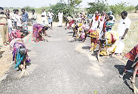 சாலையை துடைப்பத்தால் சுத்தம் செய்து கிராம மக்கள் நூதன போராட்டம் பூதலூர் அருகே பரபரப்பு