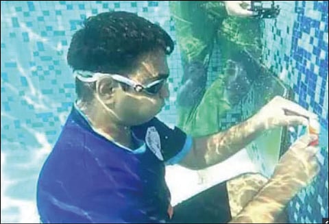 தண்ணீருக்குள் அமர்ந்து ‘ரூபிக்ஸ் கியூப்' விளையாடி மும்பை வாலிபர் கின்னஸ் சாதனை