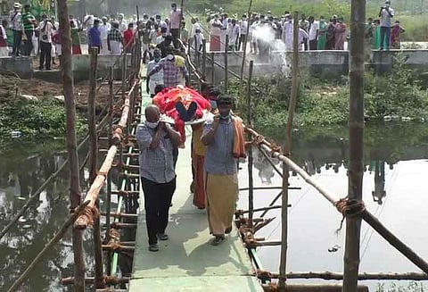 ஓடையின் குறுக்கே தற்காலிக பாலம் அமைத்து இறந்தவர் உடலை சுமந்து செல்லும் அவலம்