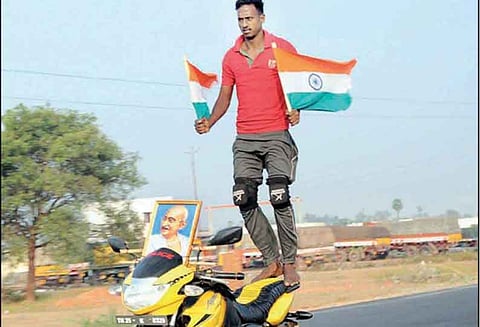கைகளில் தேசிய கொடிகளை ஏந்தியவாறு மோட்டார் சைக்கிள் ஓட்டிய பட்டதாரி வாலிபர்