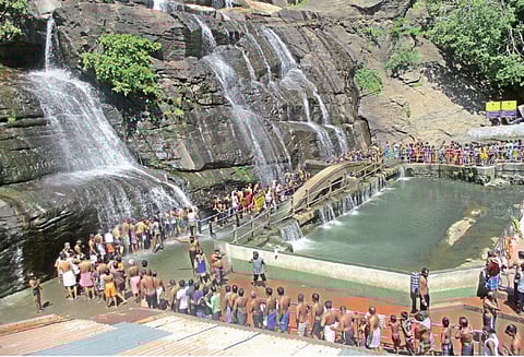 குற்றால அருவிகளில் தண்ணீர் குறைந்தது சுற்றுலா பயணிகள் வரிசையில் நின்று குளித்தனர்