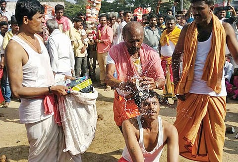 தலையில் தேங்காய் உடைத்து பக்தர்கள் நேர்த்திக்கடன்