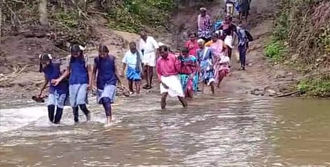 கடம்பூர் அருகே சேறு, சகதி காரணமாக காட்டாற்றை பஸ் கடக்க முடியாததால் போக்குவரத்து பாதிப்பு- ஆபத்தை உணராமல் வெள்ளத்தை கடந்து செல்லும் மாணவ, மாணவிகள்