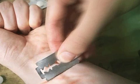 போலீஸ் நிலையத்தில் வைத்து பிளேடால் தன்னை தானே அறுத்து வாலிபர் தற்கொலை முயற்சி