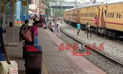 சிக்னலுக்காக நிறுத்தப்பட்ட ரெயிலில் இருந்து இறங்கி ஆபத்தான முறையில் தண்டவாளத்தை கடக்கும் பயணிகள்