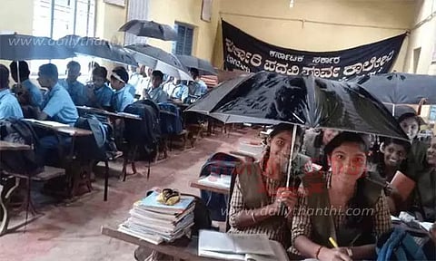 மழைநீர் கசிவால் வகுப்பறையில் குடை பிடித்தப்படி கல்வி பயிலும் மாணவர்கள்