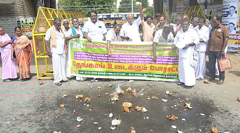 தேங்காய்களை உடைத்து விவசாயிகள் போராட்டம்
