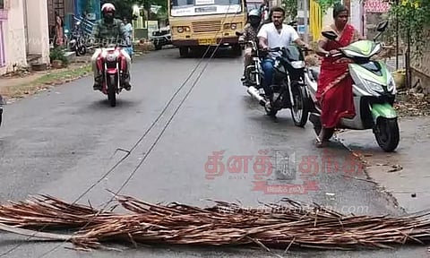 சூறைக்காற்றில் சாலையில் அறுந்து விழுந்த மின்கம்பிகள்