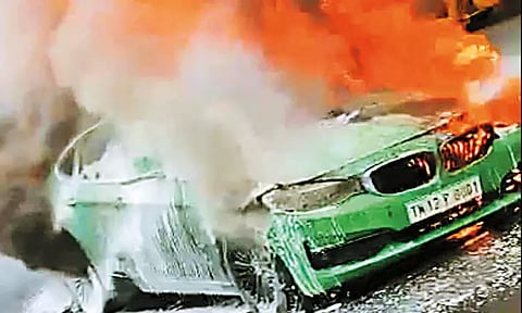 சொகுசு கார் தீப்பிடித்து எரிந்ததால் பரபரப்பு போக்குவரத்து பாதிப்பு
