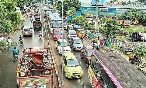 கோவூர் அருகே மேம்பாலத்தின் கீழ் குண்டும் குழியுமான சாலையால் வாகன நெரிசல்