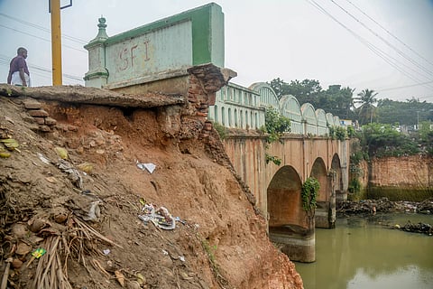 இடிந்து விழும் நிலையில் பாலத்தின் பக்கவாட்டு சுவர்