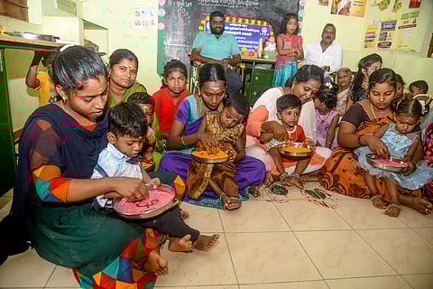 பெற்றோர்களின் மடியில் அமர்ந்து வித்யாரம்பம் எழுதிய குழந்தைகள்