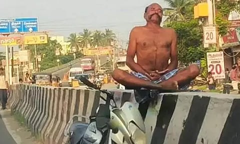 தலைக்கேறிய மதுபோதை.. சாலை தடுப்புச் சுவரில் அமர்ந்து யோகாசனம் செய்த நபர்