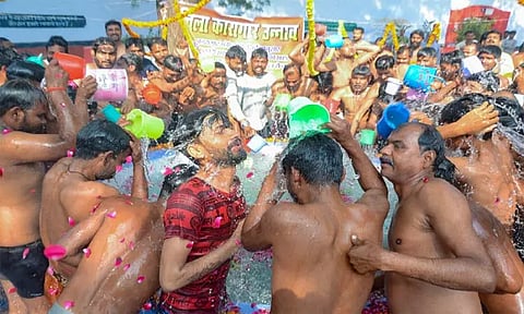Prisoners take a bathe with the holy water brought from Prayagraj's Sangam, at the district jail in Unnao