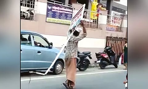 குடிபோதையில் 'நோ பார்க்கிங்' பலகையை தூக்கி சென்ற மதுபிரியர்