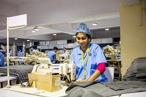 This collected photo shows a female worker operating sewing machine in a garment factory in Bangladesh