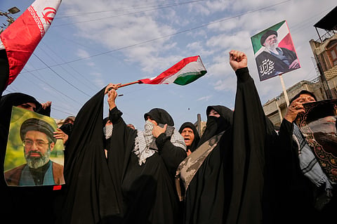 Supporters carrying Iranian flags and portraits of Ayatollah Ali Khamenei in Khamenei's funeral procession