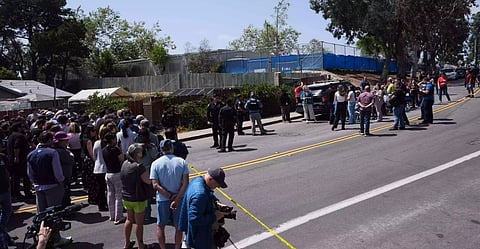 A crowd gathers near the scene of a shooting outside the Islamic Center of San Diego Monday, 18 May, 2026, in San Diego. (AP Photo/Gregory Bull)