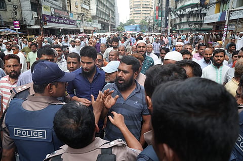 A policeman tries to urge a protester to leave the streets following demonstrations outside the Islami Bank's head office in the capital on 1 June, 2026. 