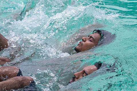 Two men take a dip in the Dhaka University swimming pool to escape the scorching heat amid an ongoing heat wave 