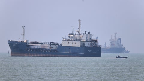 A small motorboat passes anchored vessels in the Strait of Hormuz off Bandar Abbas, Iran, Wednesday, 17 June 2026.