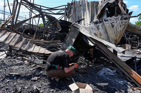 An owner rummages through the ashes on the site of the ruined city marketplace after Russian recent missile attack in Kyiv, Ukraine, Wednesday, 24 June 2026.