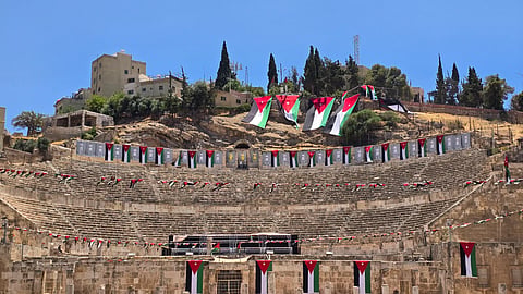 National flags of Jordan and posters of Jordan's FIFA World Cup players hanging in front of the Roman Theater, a 2nd-century landmark in Amman, Jordan.