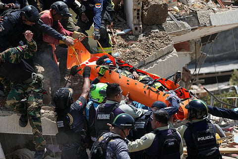 Rescue workers pull Moises Calzadilla, 11, from the rubble three days after earthquakes struck La Guaira, Venezuela