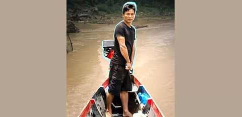 Tindu Junior Secondary School Headmaster Bamong Khyang Minglen operates a motorised boat on the Thanchi-Tindu-Remakri river route during holidays