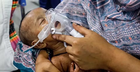 A mother nurses her child suffering from measles