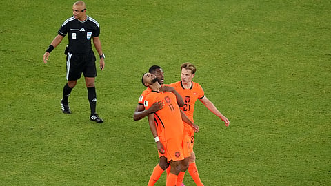 Netherlands' Cody Gakpo (11) celebrates with Denzel Dumfries (22) and Frenkie de Jong (21) after scoring their first goal during the World Cup round of 32 match between the Netherlands and Morocco in Guadalupe, Mexico on Tuesday.

