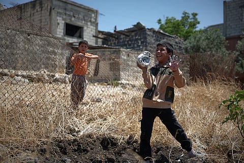 A local boy plays with the remains of an exploded Israeli shell as another boy looks on in the village of Abdin, Daraa province, Syria, 29 June 2026.